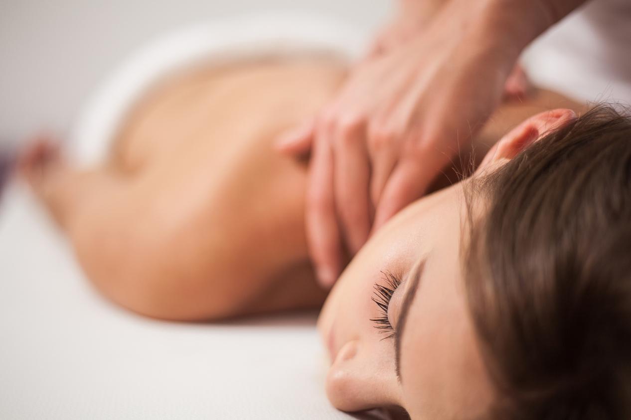 Young woman receiving back massage at spa